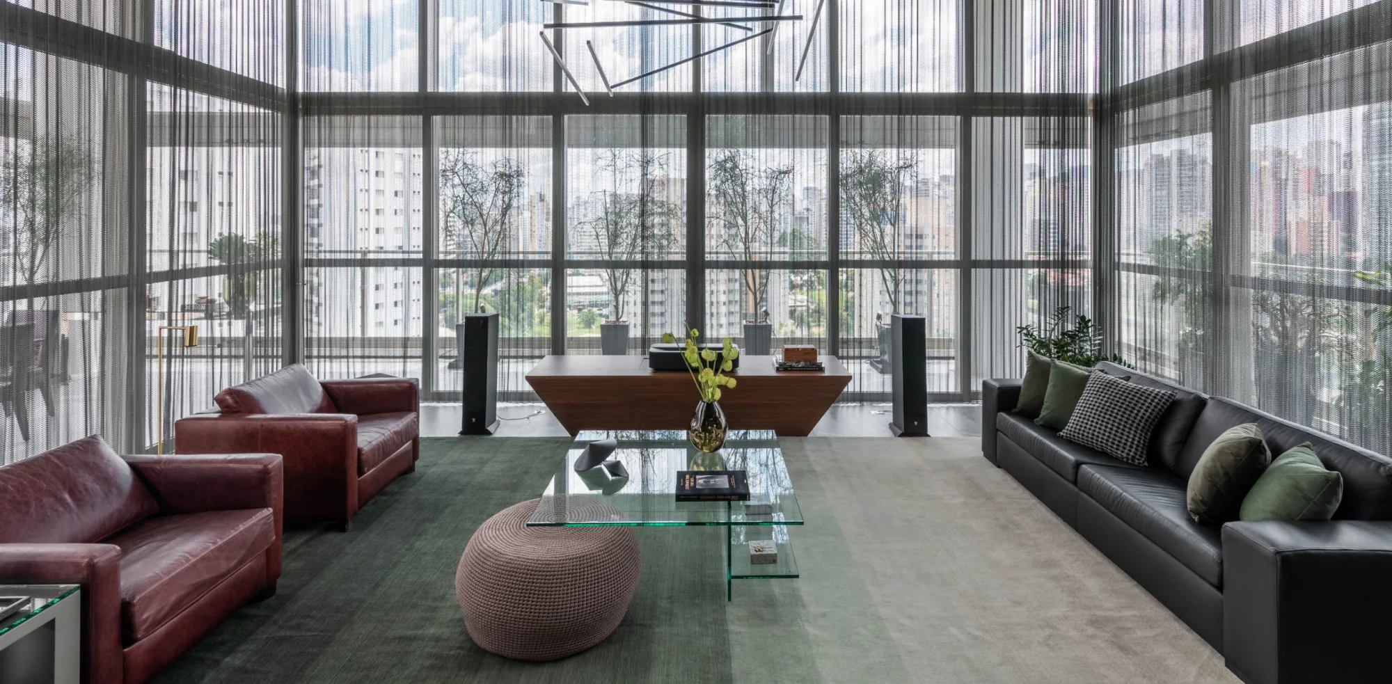 Sala de estar de um projeto C2H, com tapete verde-sálvia e vista para São Paulo